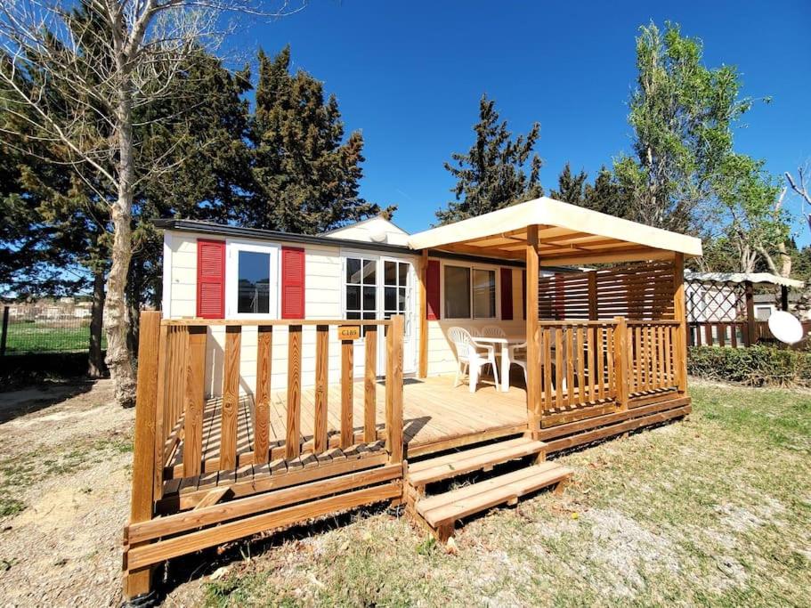 a small cabin with a deck in the grass at Bungalow L&#39;Estagnol - 3 chambres in Sigean