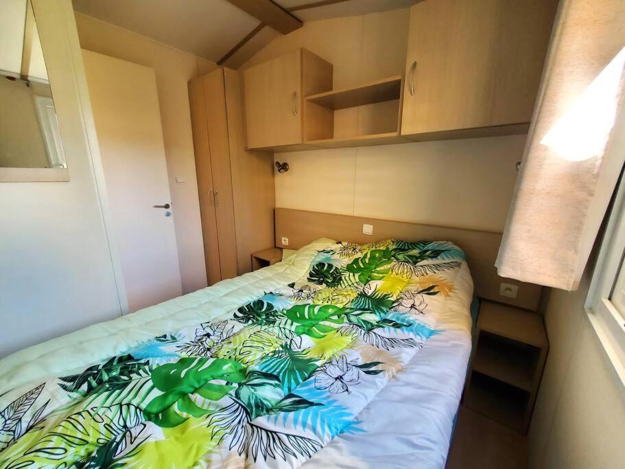 a small bedroom with a bed with a colorful blanket at Bungalow L&#39;Estagnol - 3 chambres in Sigean