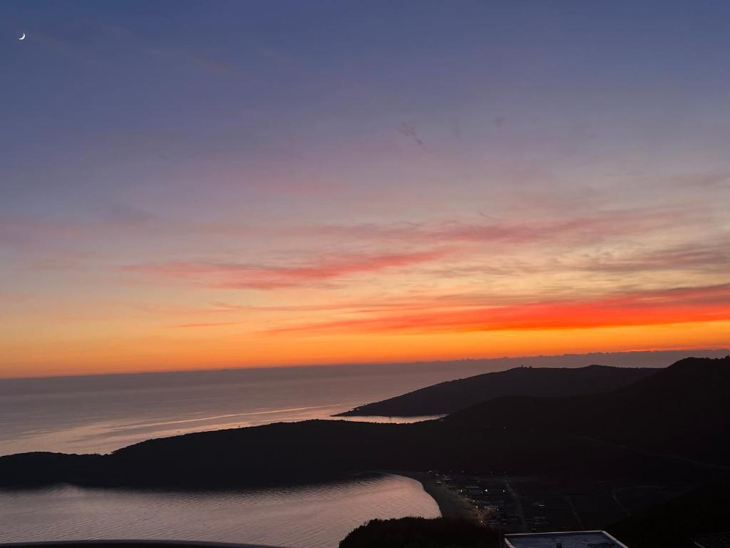 a sunset over a body of water with mountains at Apartments Villa Vanja in Budva