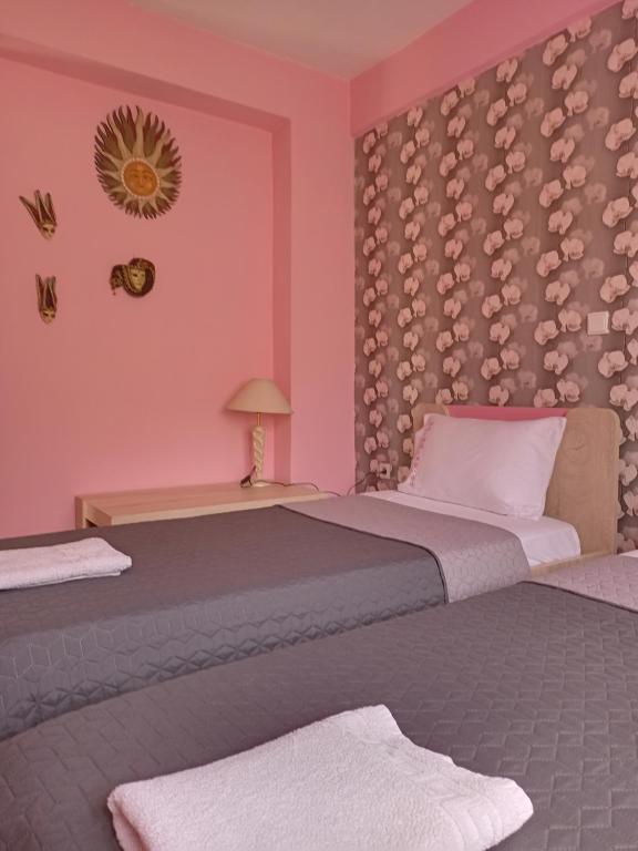 2 camas en una habitación con paredes rosas en VILLA MALILA, en Panayia