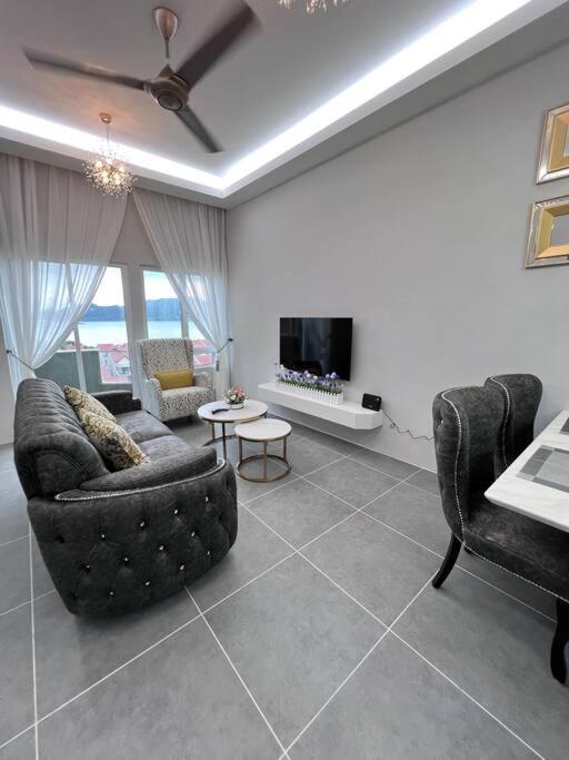 ein Wohnzimmer mit 2 Sofas und einem TV in der Unterkunft Ocean View 611 in Kuah