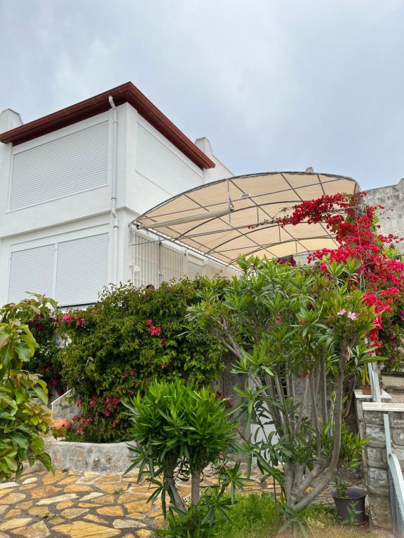 a white house with a roof with flowers and plants at Viva Bella Vista - near the Beach and AirPort in Dalaman