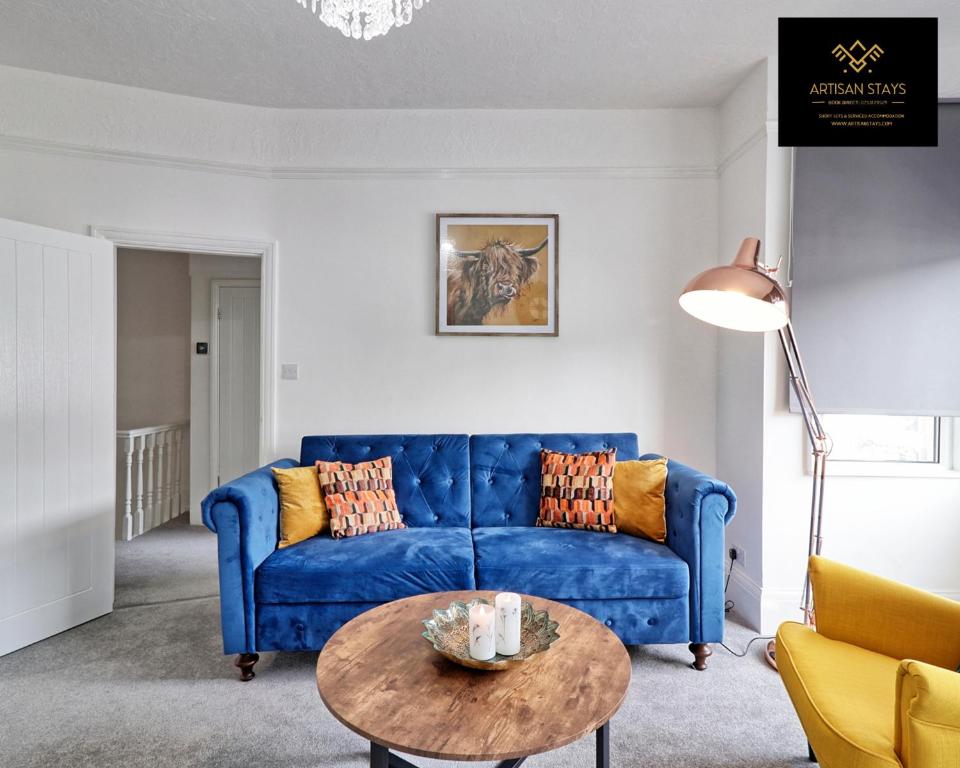 a living room with a blue couch and a table at Luxury Furnished Apartment in Southend-On-Sea by Artisan Stays I Weekly & Monthly Stay Offer I Book NOW in Southend-on-Sea
