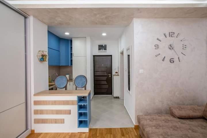a living room with a large clock on the wall at ApartmentJakovNiksic in Nikšić