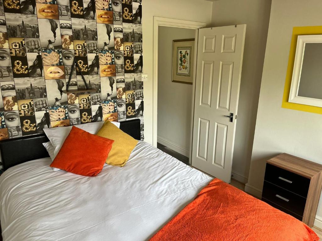a bedroom with a bed and a wall with pictures at Swindon Home from Home 2 - EnterCloud9SA in Swindon
