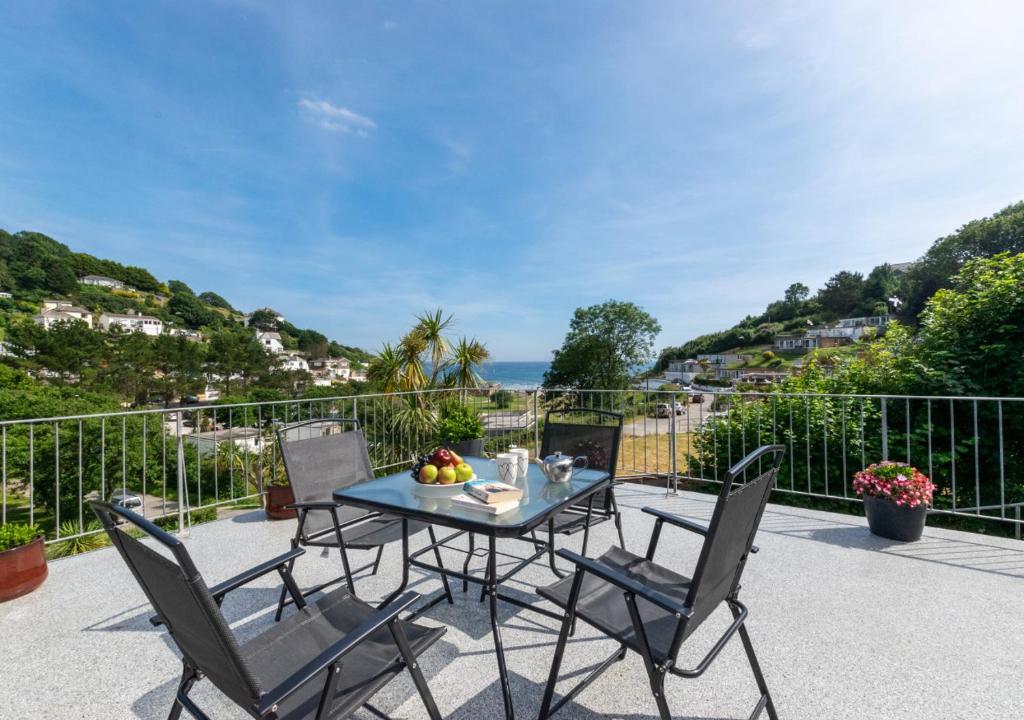 einen Tisch und Stühle auf einer Terrasse mit Meerblick in der Unterkunft Villa 49 Millendreath Beach Resort in Saint Martin