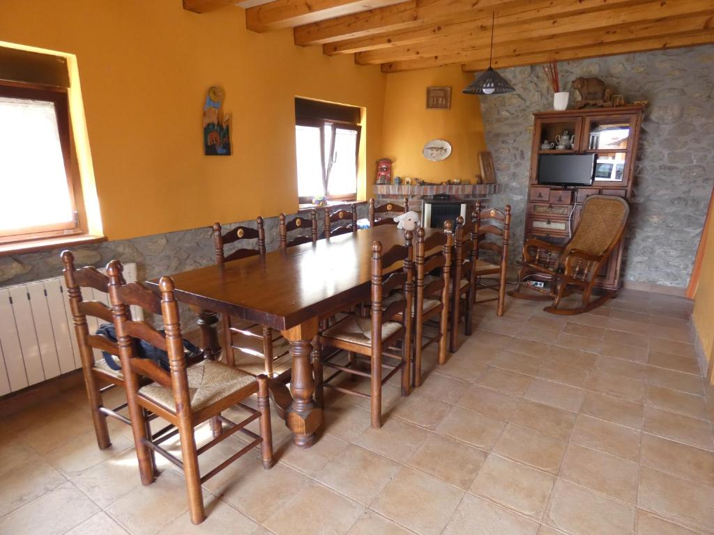 een eetkamer met een houten tafel en stoelen bij Alojamiento Turístico Prellezo in Prellezo