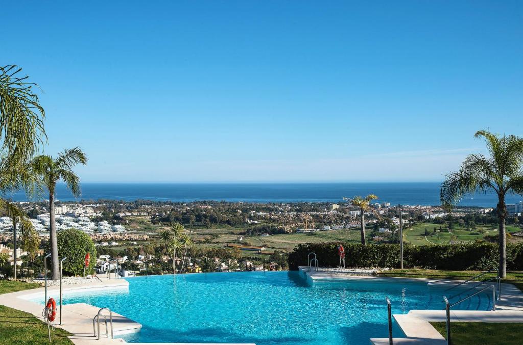 a large swimming pool with a view of the ocean at Wonderful 3-bedroom apartment with garden and amazing views Hacienda Senorio Cifuentes Marbella in Benahavís