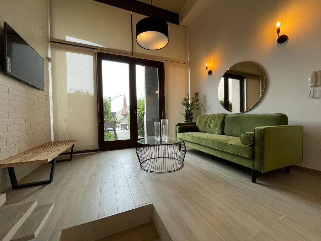 ein Wohnzimmer mit einem grünen Sofa und einem Spiegel in der Unterkunft Espectacular Loft conEstacionamiento en Valparaíso Servicio HOM in Valparaíso