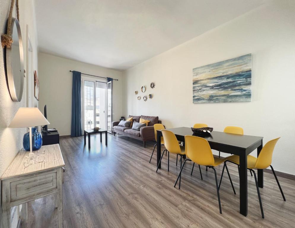 a living room with a dining room table and yellow chairs at Stay U-nique Apartments Sagrada Familia in Barcelona