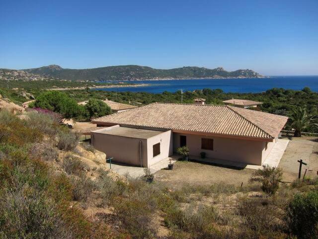 une petite maison sur une colline à côté de l'océan dans l'établissement GRANDE VILLA TIZZANO A 200 M DE LA PLAGE 18 PERS, à Sartène