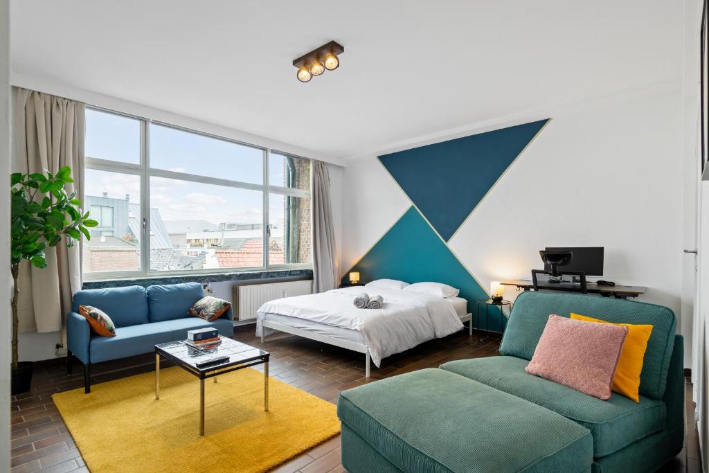 a room with a bed and a couch and a bed and a room with at Cozy Antwerp - Cityview Studio FREE PARKING in Antwerp
