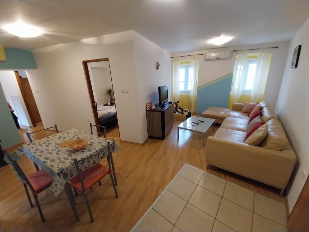 a living room with a couch and a table at Apartmani Jadran in Mali Lošinj