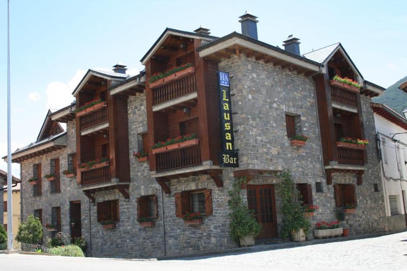 a large stone building with a sign on it at Apartamentos Lausan in Gavín