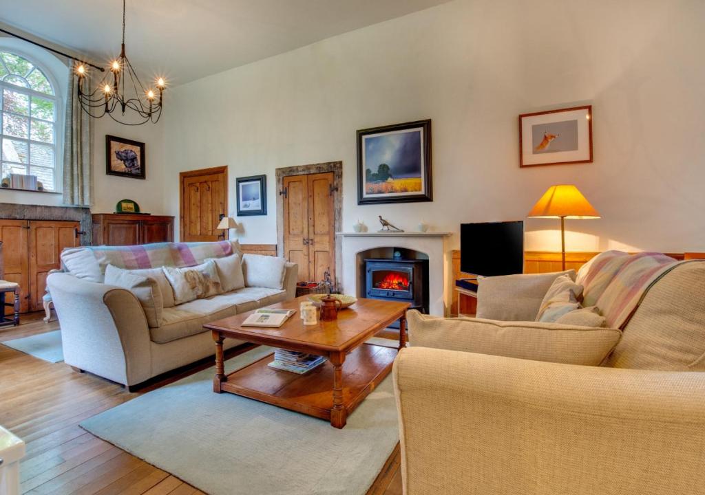 a living room filled with furniture and a fire place at Monks Bridge in Crosby Ravensworth