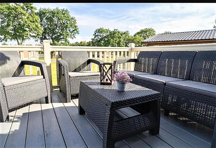 a patio with wicker chairs and a table on a deck at Moore Lodge with Hot Tub in Barmby on the Moor