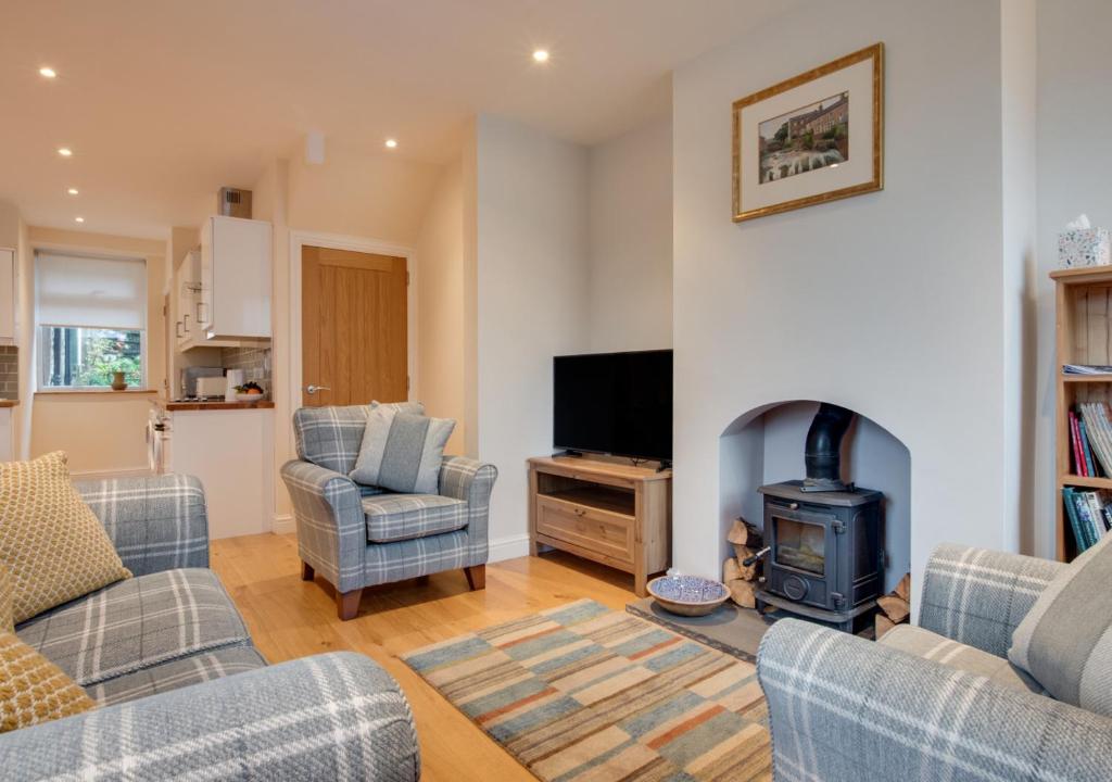 a living room with two couches and a fire place at Wilmer House in Hawes