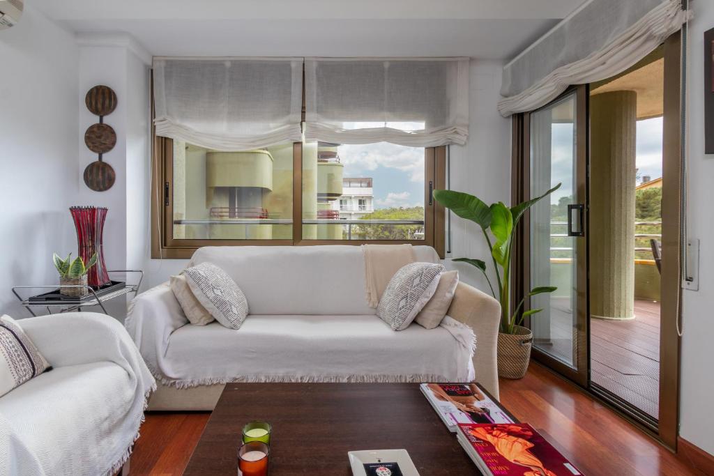 a living room with a white couch and a window at Maria Beach in Platja  d'Aro