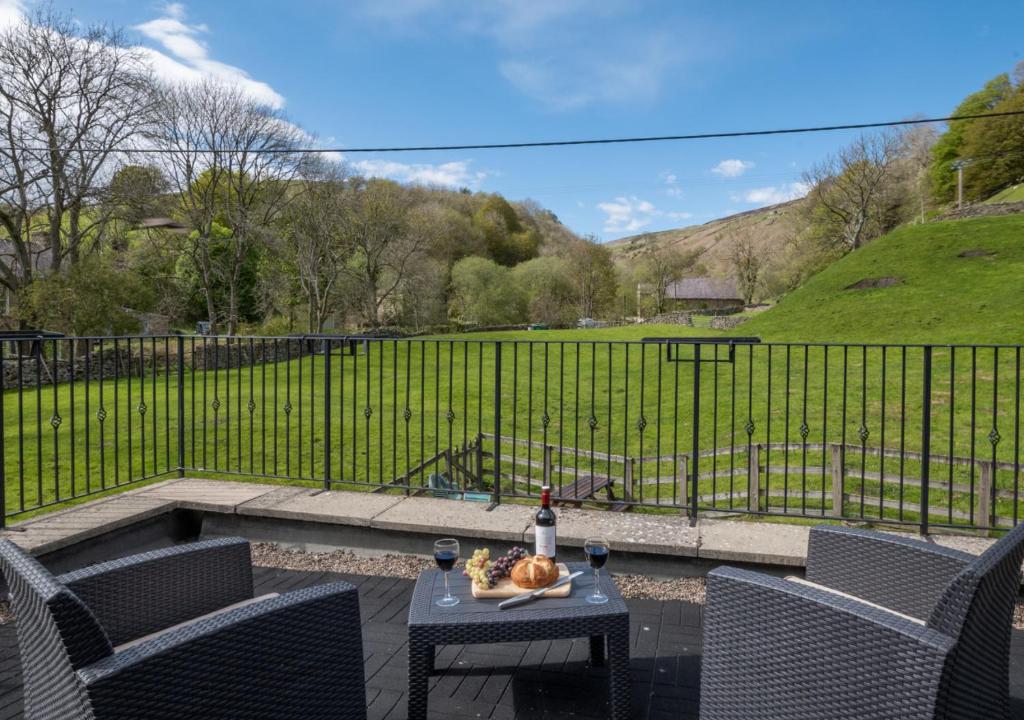 a patio with a table and chairs and a fence at Ghyllfoot Apartment in Gunnerside