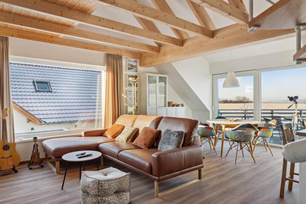 sala de estar con sofá de cuero y mesa en Wohnung in Baddeckenstedt mit Balkon & Aussicht en Baddeckenstedt