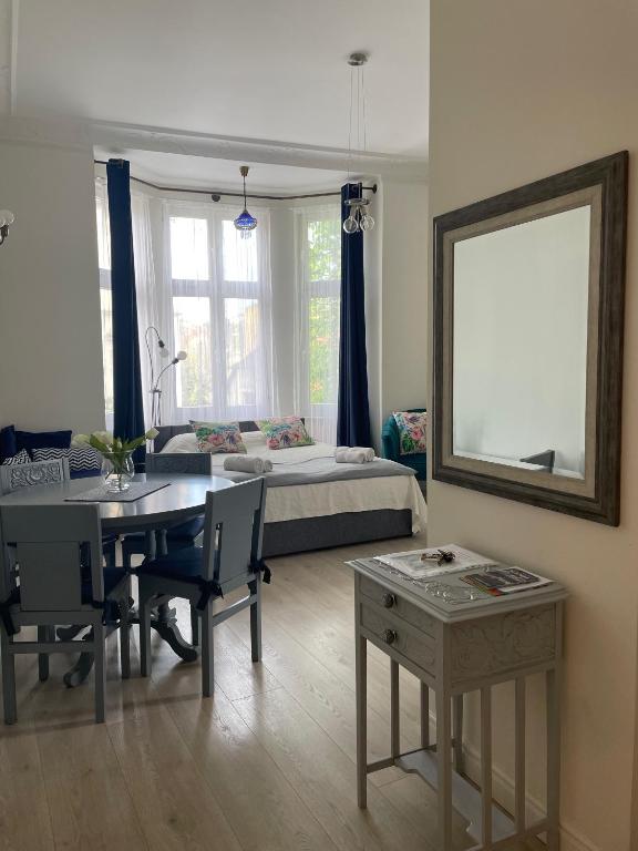 a living room with a dining table and a bed at Sopot Monte Cassino Wiktoria Apt in Sopot
