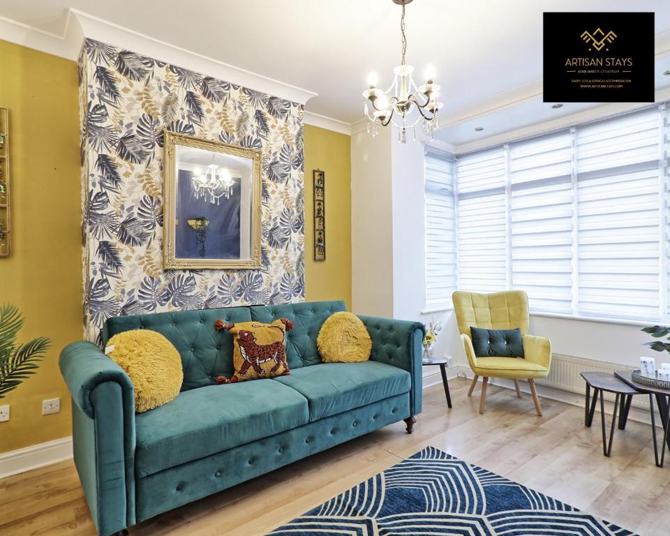 sala de estar con sofá azul y silla en Stunning Tropical Oasis By Artisan Stays I Free Parking I Long-stay Offer I Relocation or Business, en Southend-on-Sea