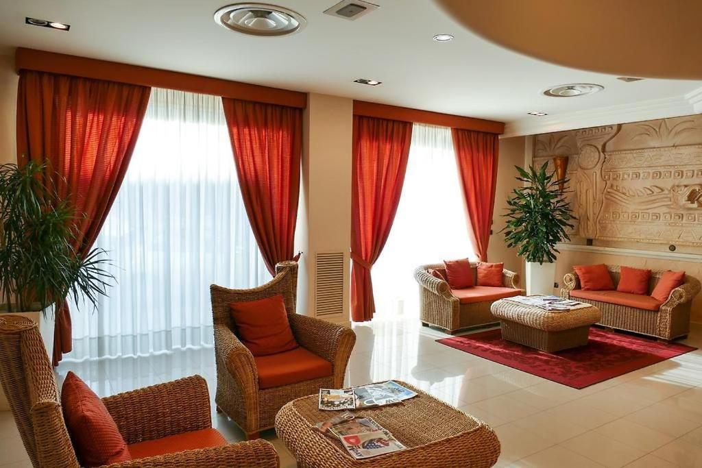 una gran sala de estar con cortinas y sillas rojas en STELLA CHARMING & LUXURY ROOMS, en Conversano