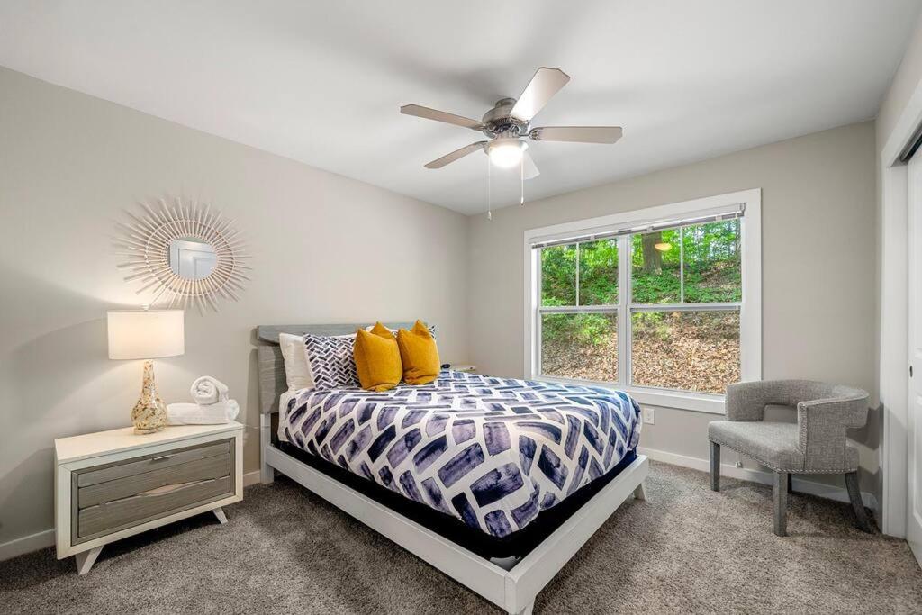 um quarto com uma cama, uma ventoinha de tecto e uma cadeira em High-end on a budget at Truist Park em Atlanta