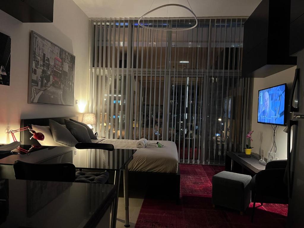 1 dormitorio con 1 cama, TV y sofá en Super Studio in Dubai en Dubái