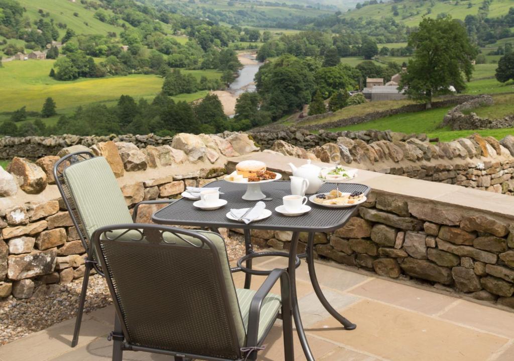 a table with plates of food on top of a stone wall at Throstle Nest House in Gunnerside