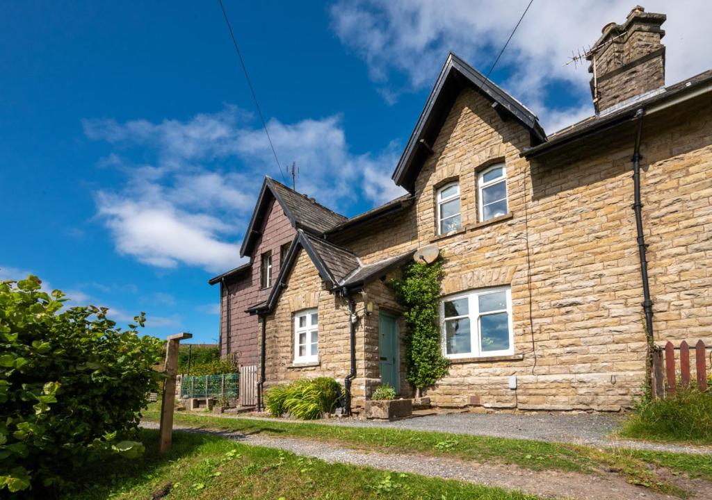 a stone cottage with a brick house at 2 Moorcock Cottages in Cotterdale