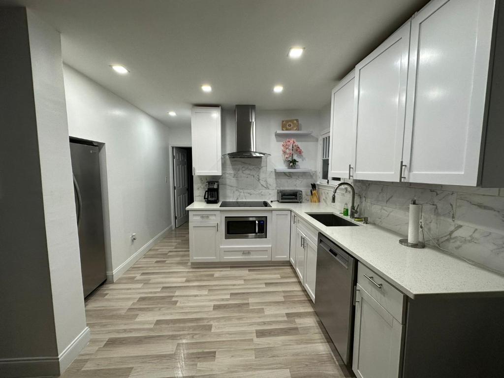 a kitchen with white cabinets and a wooden floor at 1st floor apt 3 bed/ 2 bath in downtown orlando in Orlando