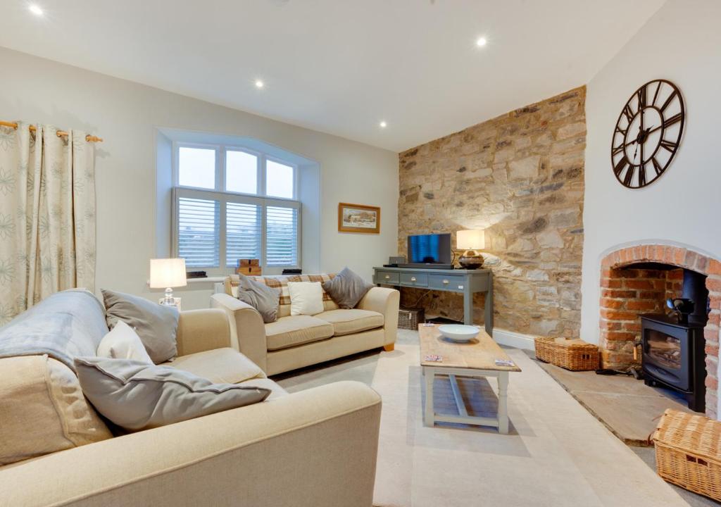 a living room with a couch and a fireplace at 2 Railway Cottages in Selside