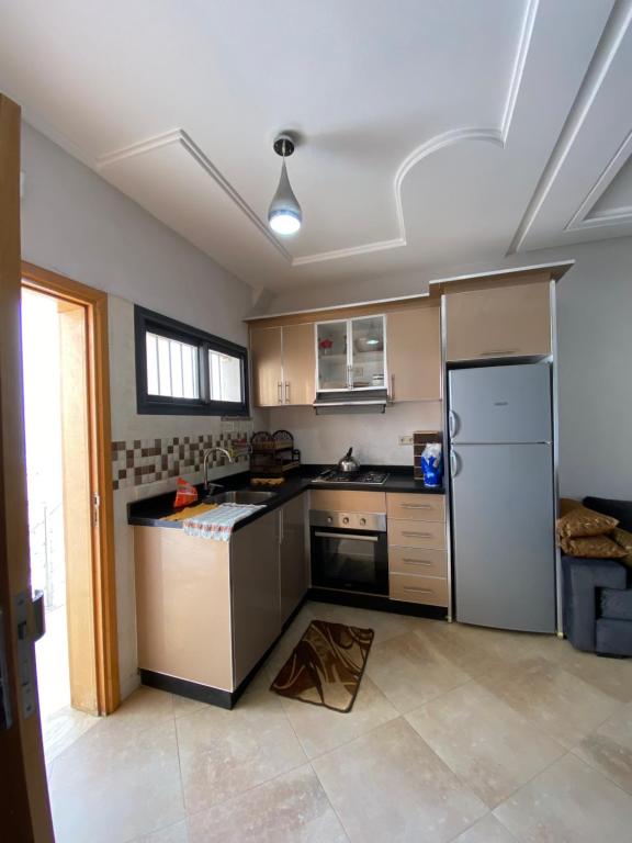an empty kitchen with a refrigerator and a stove at House of banana beach aourir in Aourir