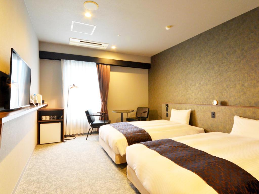 Postel nebo postele na pokoji v ubytování LC Goryokaku Hotel