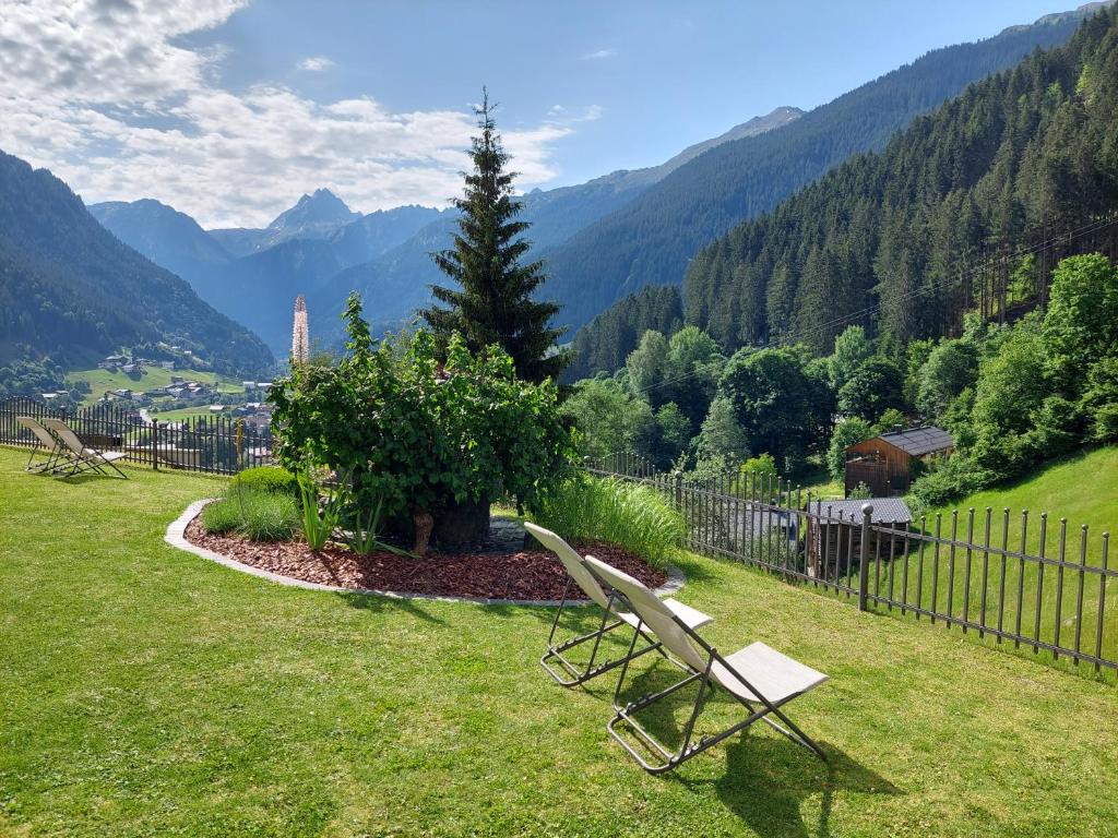 a white bench sitting on top of a grass field at Apart Alpenpension Maderer in Gaschurn