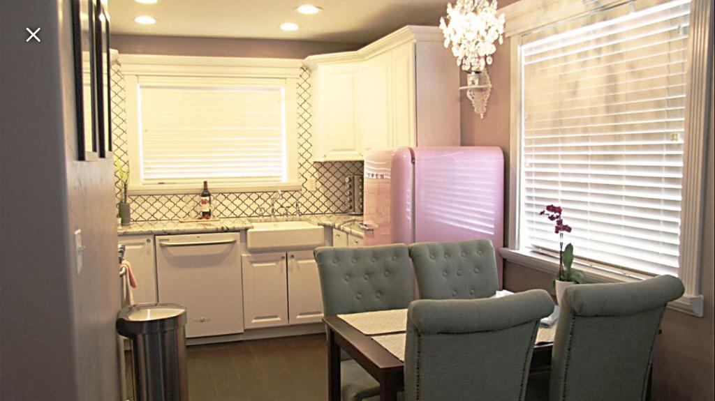 a kitchen with a table and chairs and a refrigerator at The Pink Fridge in Whitefish