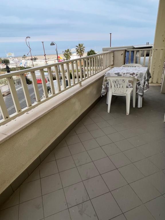 a table and chairs on a balcony with the beach at BILOCALE FRONTE MARE in Rimini