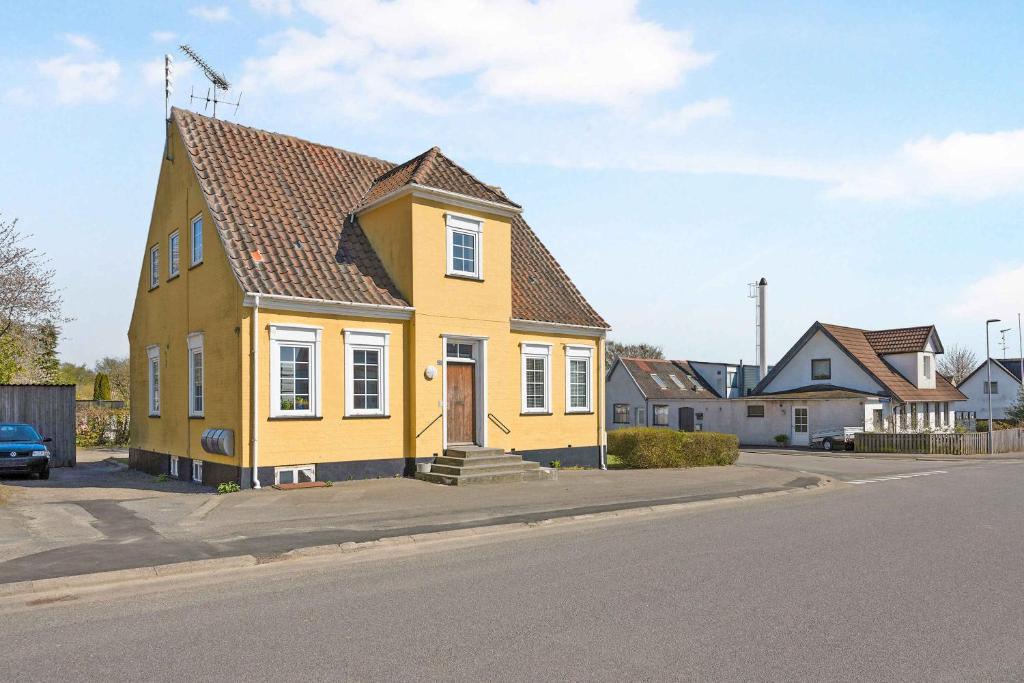 une maison jaune sur le côté d'une rue dans l'établissement Lobbk Hovedgade 22, 3720 Aakirkeby, à Åkirkeby