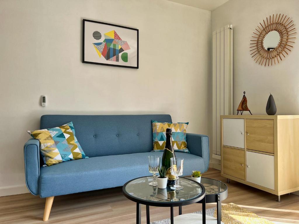 - un salon avec un canapé bleu et une table dans l'établissement T2 Centre ville avec parking gratuit, à Toulouse
