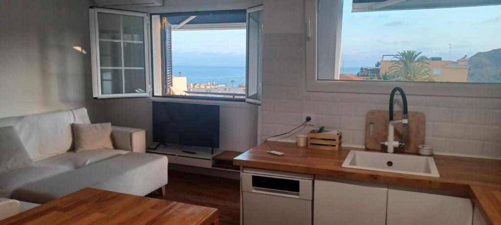 sala de estar con sofá, lavabo y TV en Apartamento burbujas playa, en Pozo del Esparto