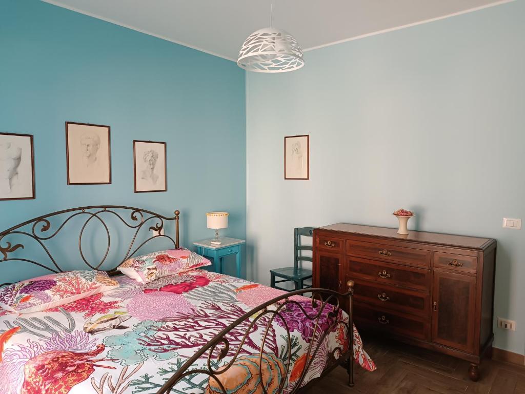 1 dormitorio con 1 cama, vestidor y pared azul en Casa Azzurra, en Giardini Naxos