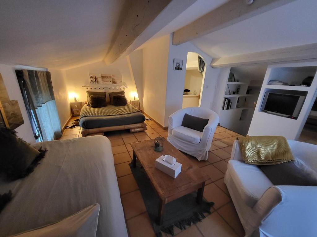 a living room with a bed and a couch at La haute verrerie in Le Cannet-des-Maures