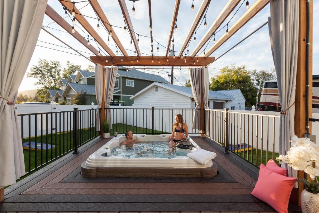 a woman and a baby sitting in a hot tub on a deck at The Manse in Whitefish