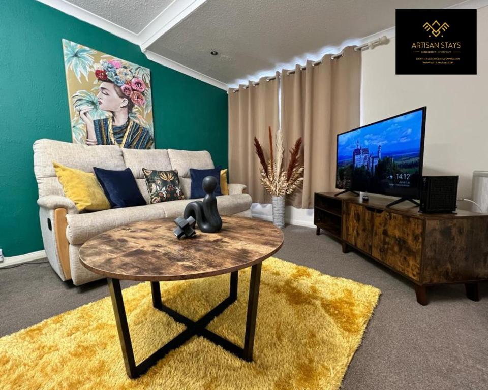 a living room with a couch and a tv and a table at The Gem of Basildon By Artisan Stays I Long Weekend Offer I Free Parking in Basildon