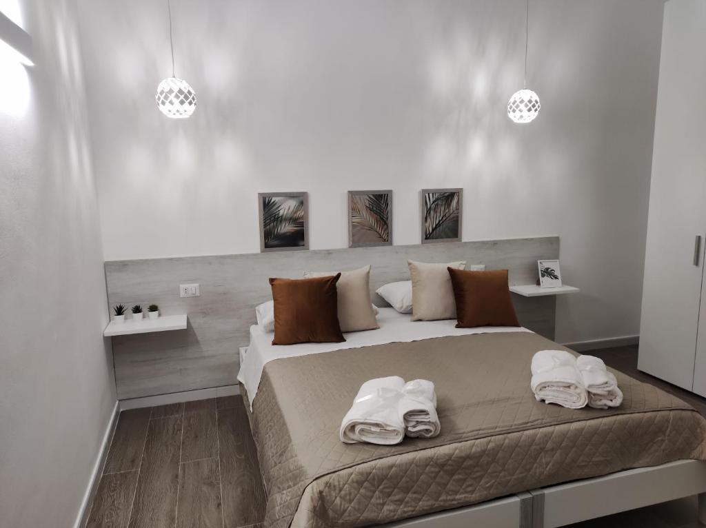 una camera da letto con un grande letto con asciugamani di Kitros a Palagiano