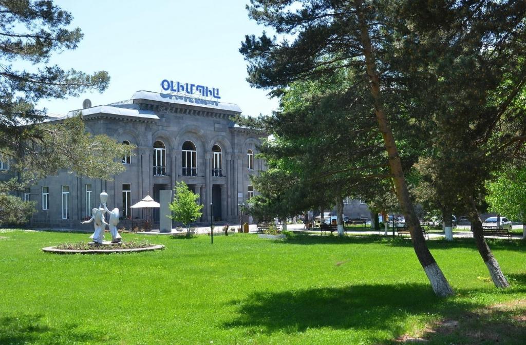 un edificio con una estatua delante de él en Jermuk Olympia Sanatorium, en Jermuk