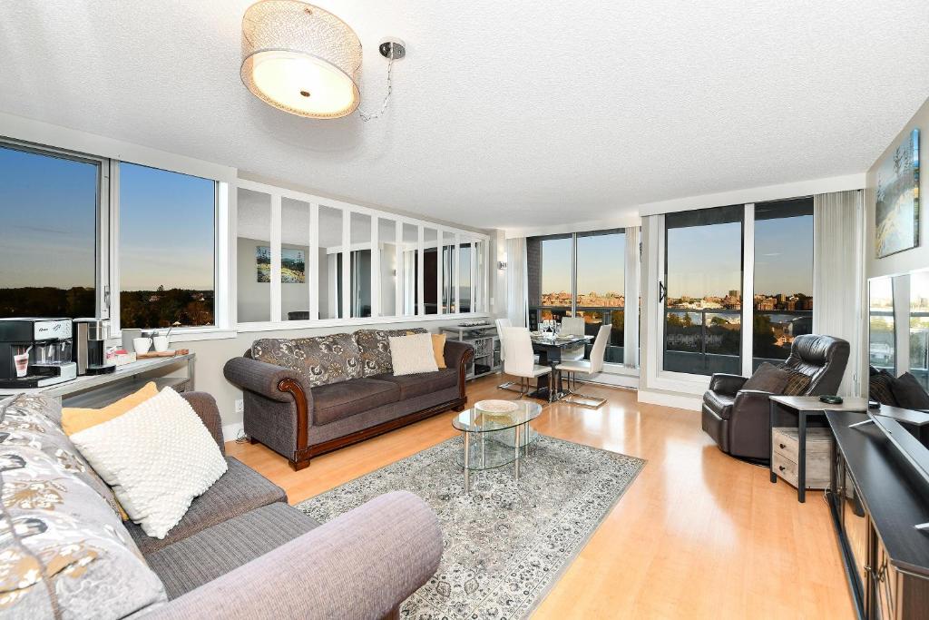 a living room with a couch and chairs and windows at Harbour Walk Executive Condo in Victoria