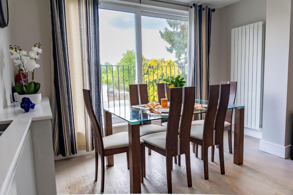 a dining room with a glass table and chairs at Star London Bell Lane 3-Bed Haven in Hendon