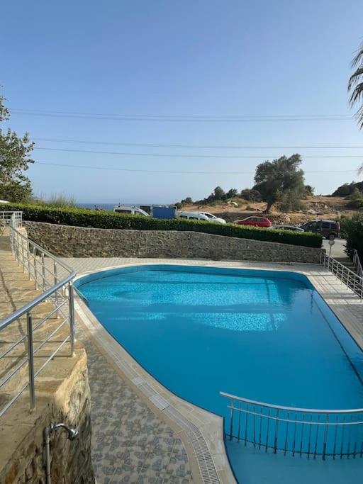 a large blue swimming pool next to a stone wall at just nearby beach peaceful place in Gazipasa